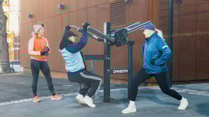 Two women and one man training at Omnigym outdoor gym in Helsinki